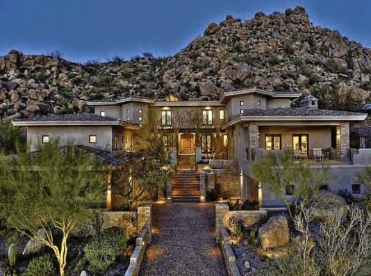 Hillside estate with landscaped entry at evening