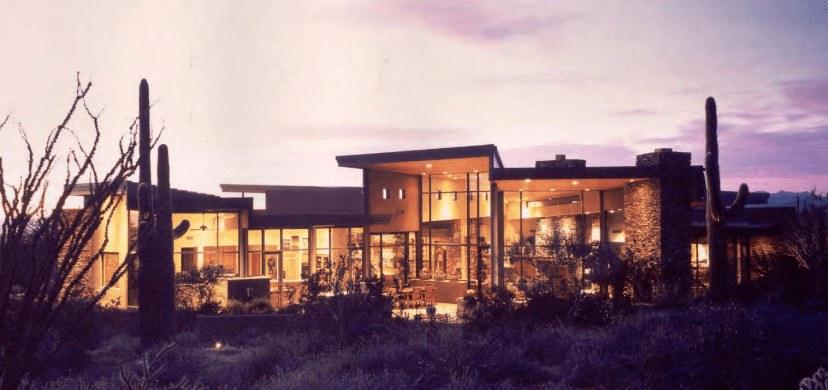 Contemporary desert home lit from within at twilight
